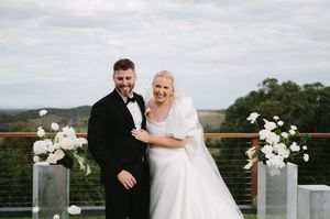 Elegant outdoor wedding ceremony with white floral arrangements and mountain views.