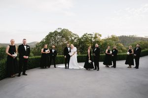 Wedding party and guests lined up for a panoramic outdoor photo.