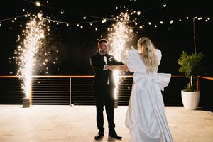 A romantic first dance at a wedding reception with sparklers creating a magical glow in the background.