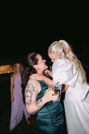 Wedding party dancing and celebrating at night with guests in formal attire.