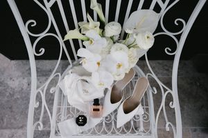 Elegant white floral arrangements and ornate metal decor create a romantic wedding ceremony setting.