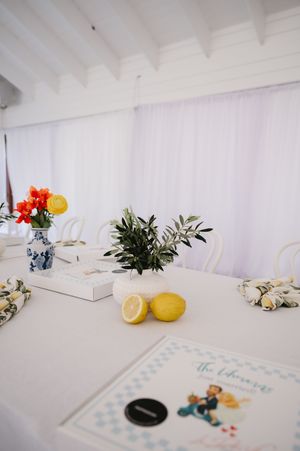 Elegant wedding decor details with fresh lemons and floral arrangements on a white surface.