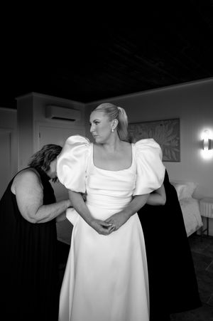 Close-up details of a white wedding dress with puff sleeves in dramatic lighting.