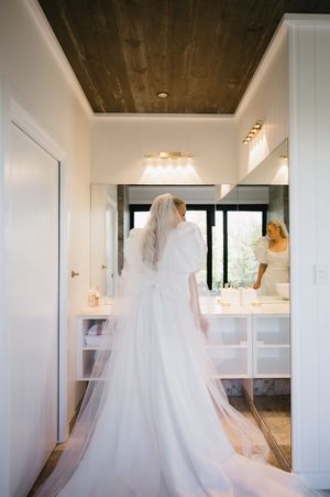 Elegant wedding dress with flowing train captured in a mirror reflection.