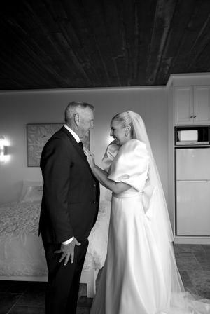 Emotional moment captured in black and white between two people in formal attire.