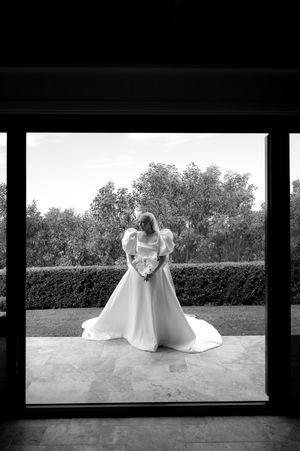 Black and white artistic wedding dress photos taken in a modern architectural setting.