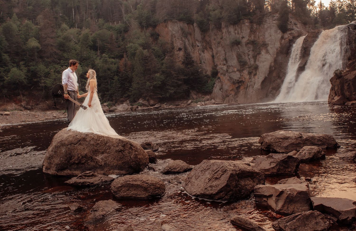 Scenic waterfall landscape with rocky terrain during sunset.