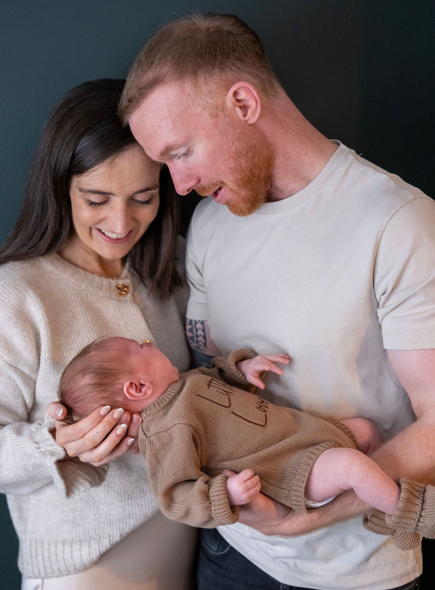 A series of intimate family portraits showing tender moments between parents and their newborn baby against a dark backdrop.