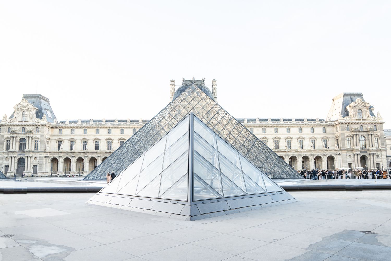 Five sequential images showing glass pyramid structures at the Louvre Museum in Paris from different angles.