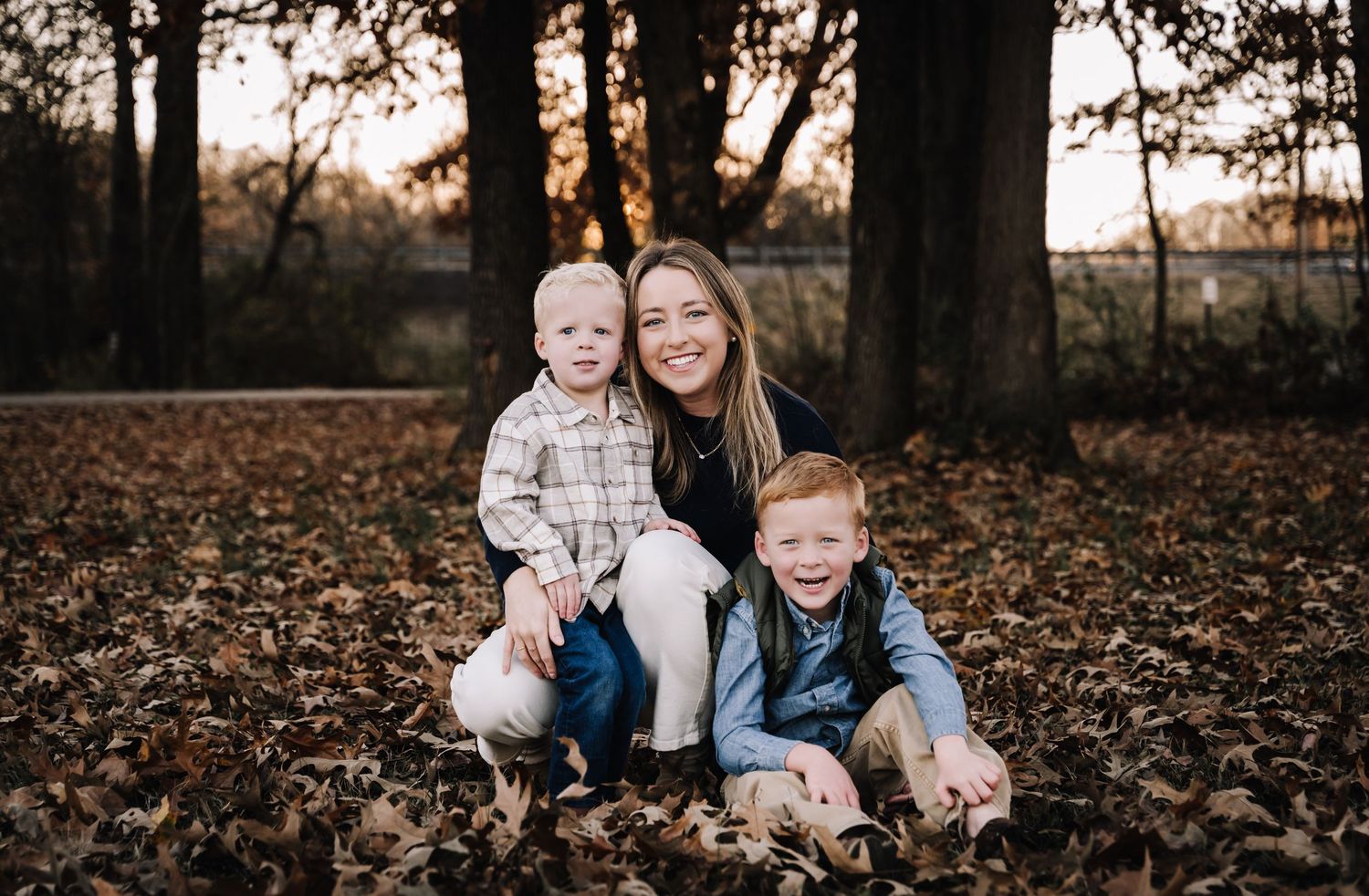 A series of autumn family portraits taken in a wooded area with fallen leaves during golden hour.