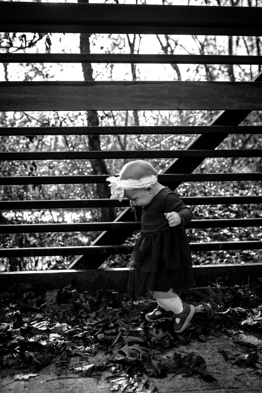 Black and white artistic photo showing legs and feet jumping in sequence against dark background.