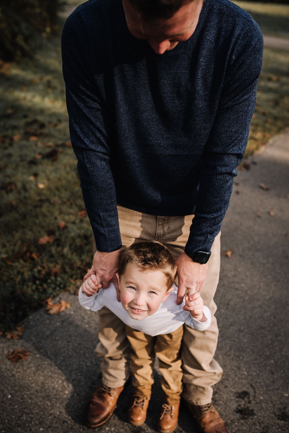 A candid moment between parent and child playing together on an autumn path.