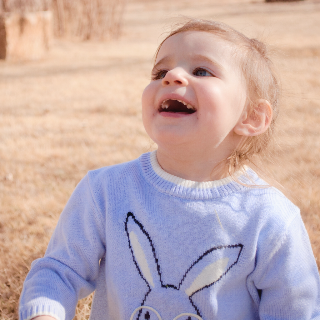 child sitting in field very happy