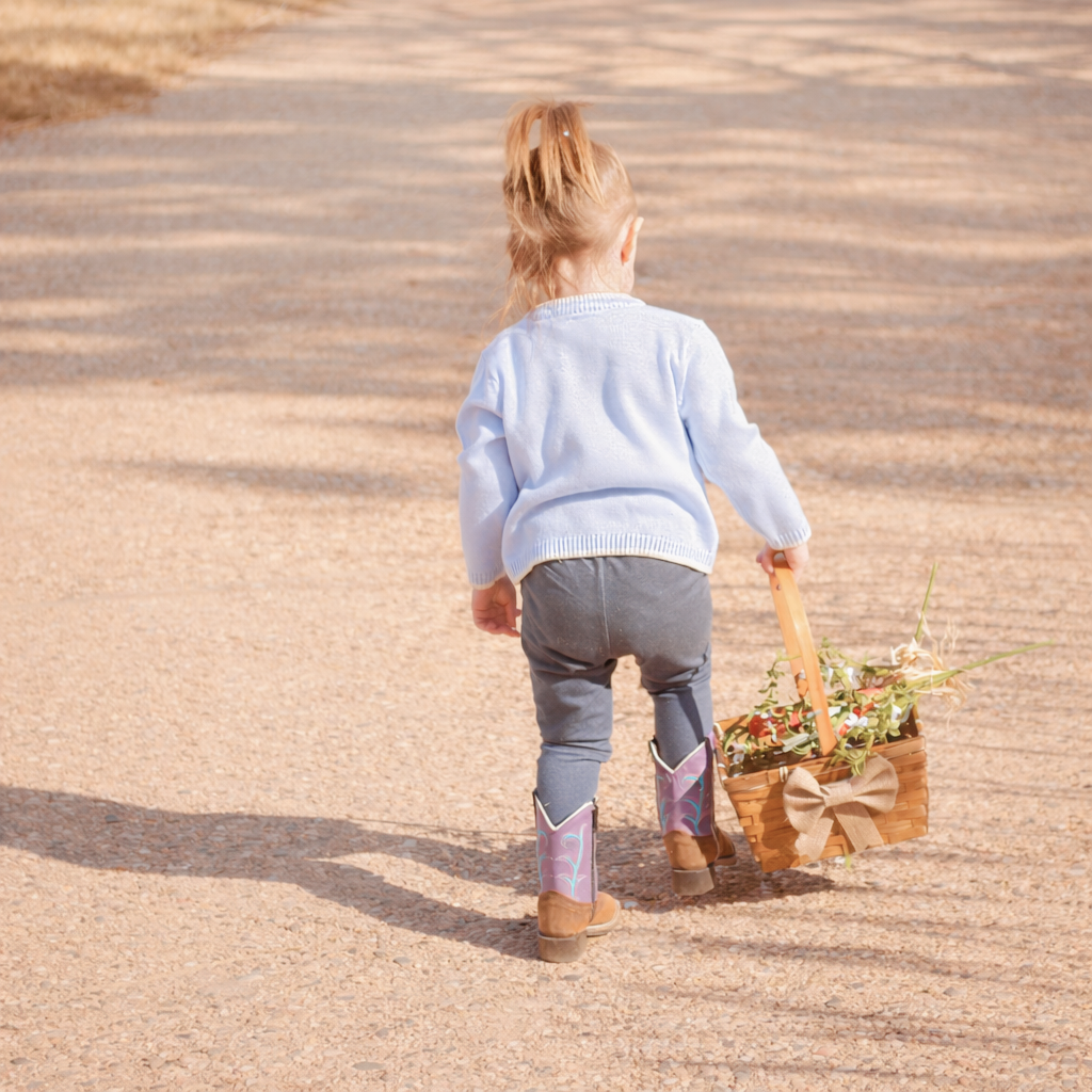 child walking on path carrying a basket
