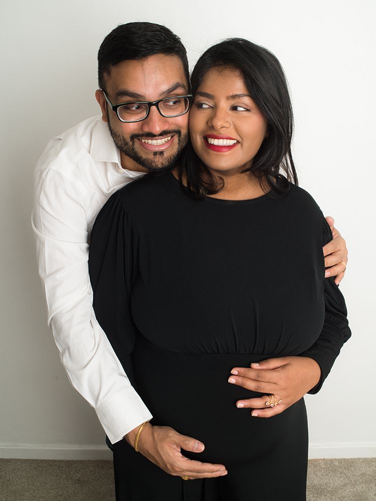 Expecting couple laughing together during  maternity photoshoot at Abigail's studio in High Wycombe