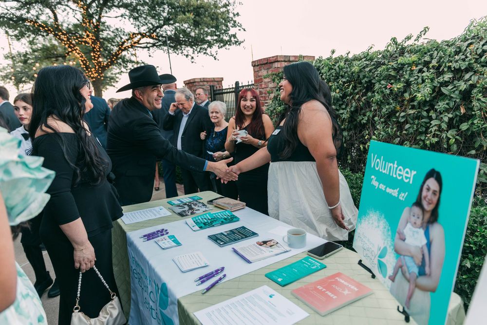 Event registration table with teal banners and marketing materials set up for guests.