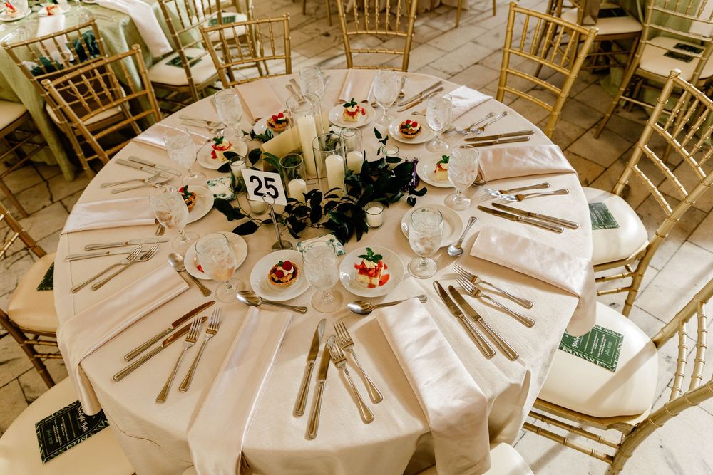 Elegant round tables set for a formal dinner with gold chiavari chairs.
