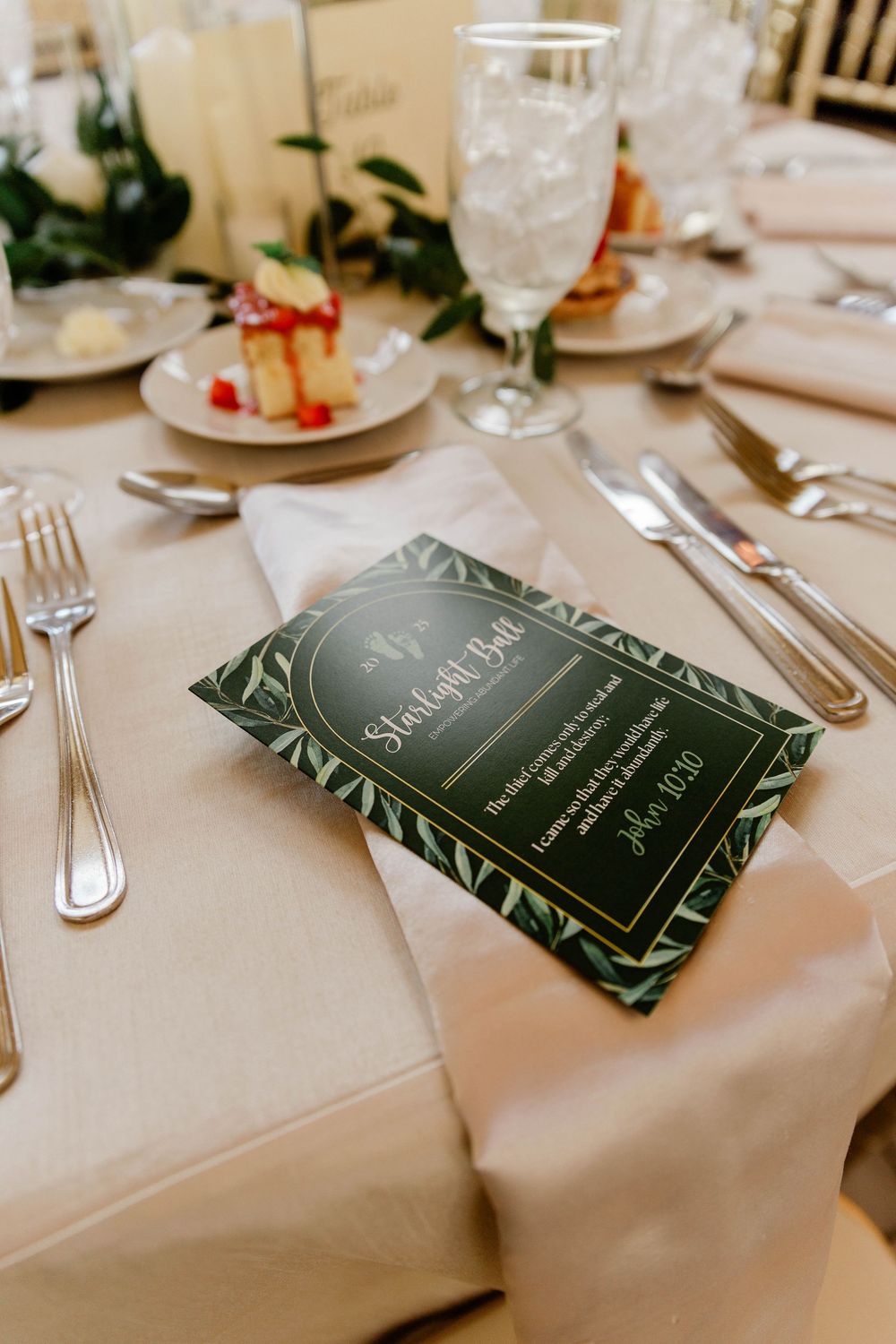 Place settings with menu cards and silverware on white tablecloths.