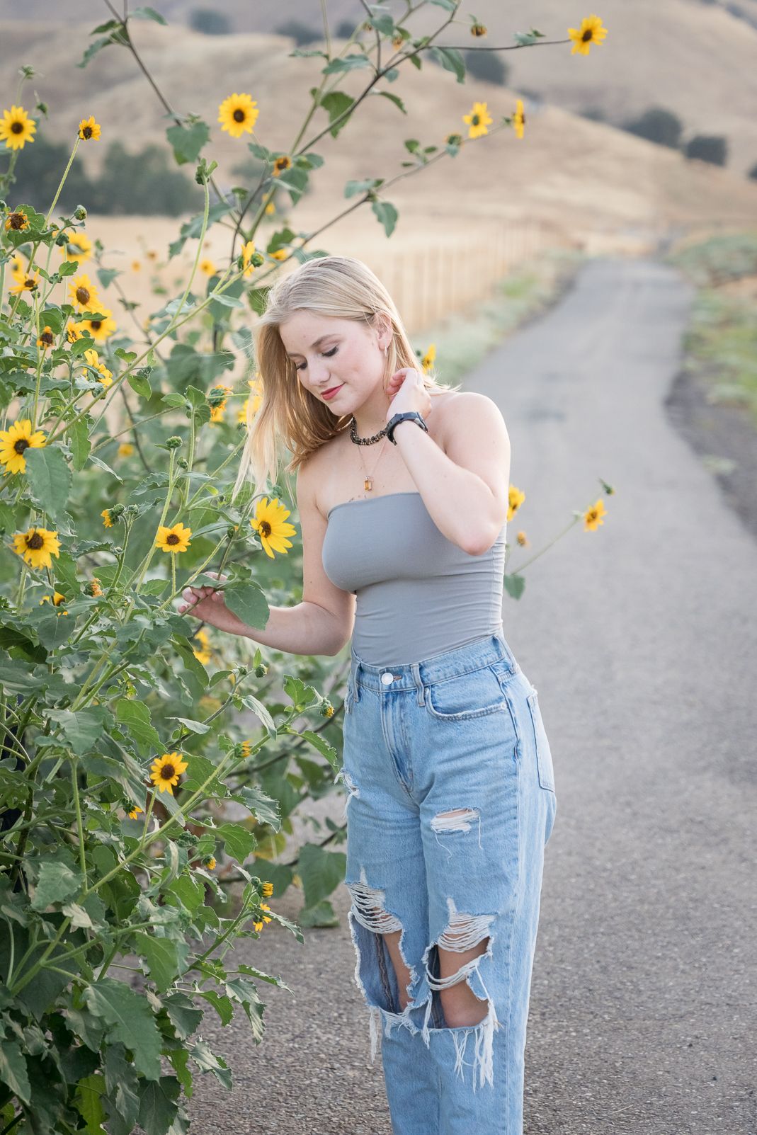 Portrait session with yellow wildflowers along winding dirt path.