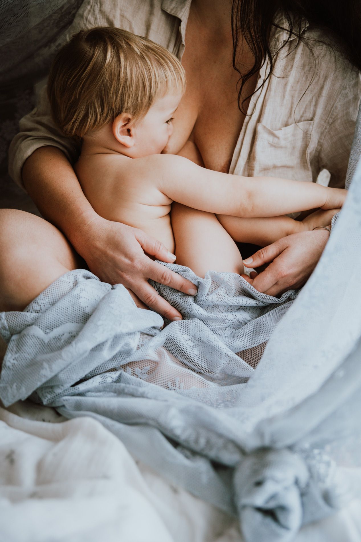 Intimate close-up series showing gentle touches and soft gray bedding in natural morning light.