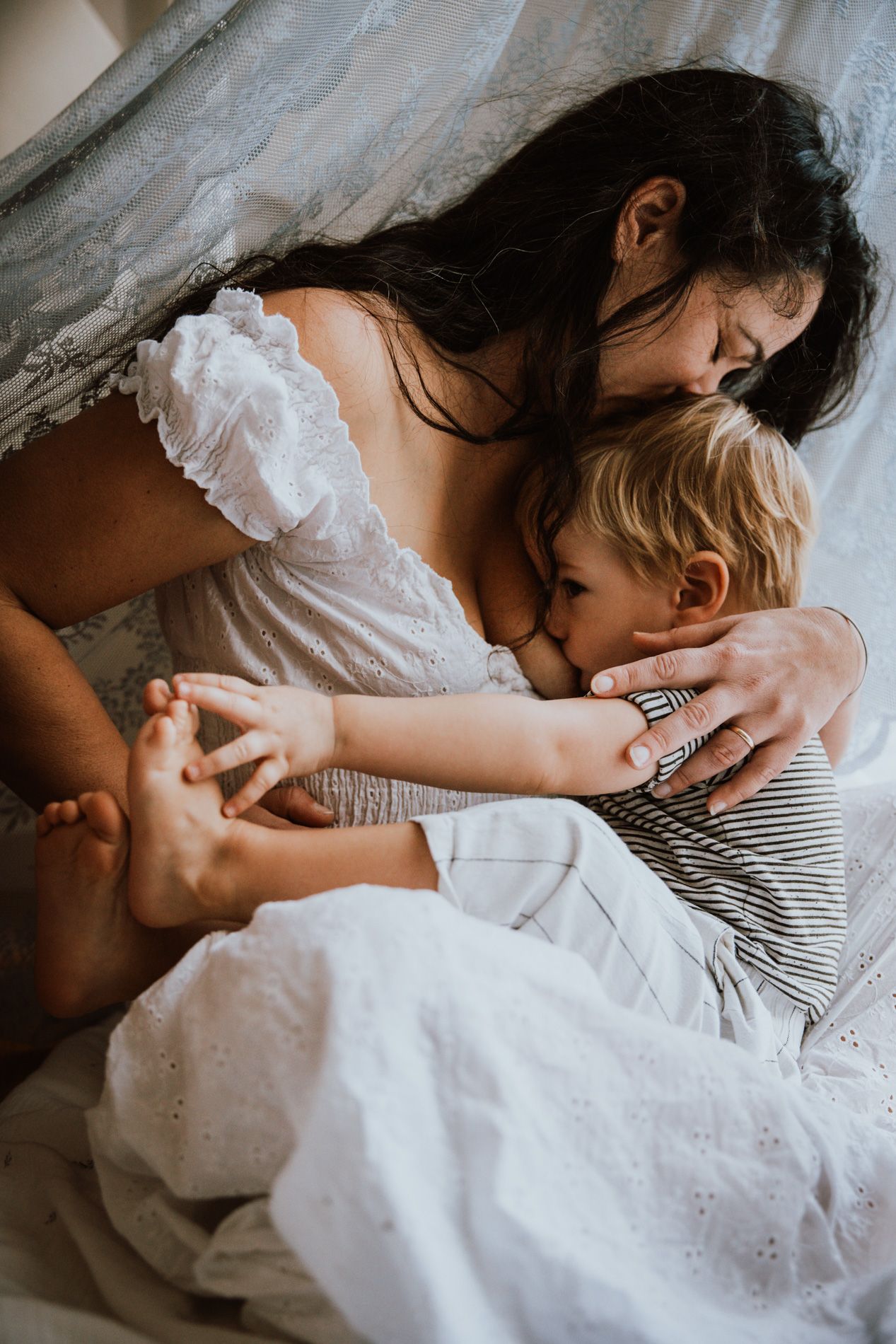 Intimate sequence of tender moments between two people in white and striped clothing lying close together.