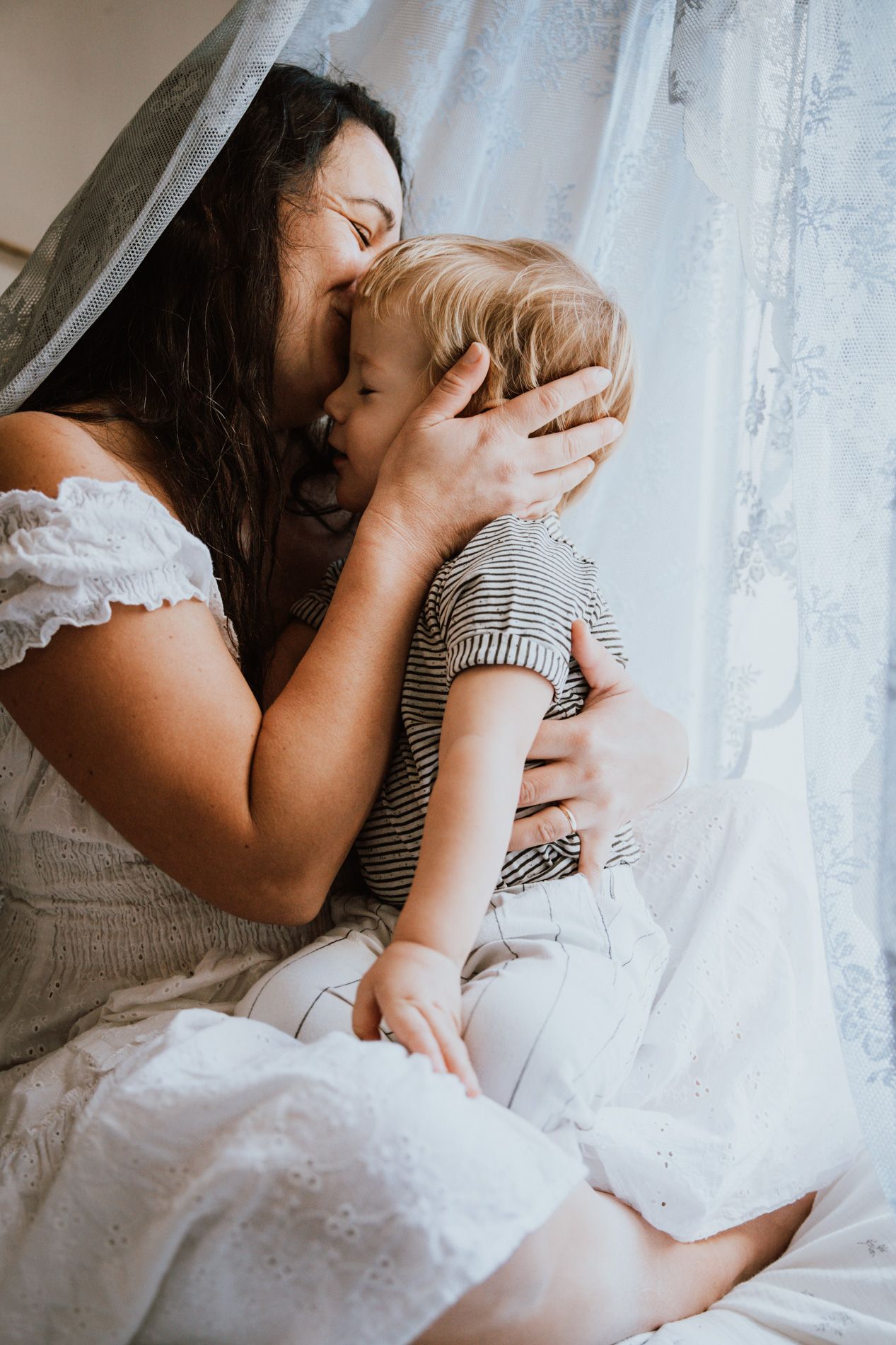 Intimate close-up series of tender moments captured in soft natural light against white lace curtains and bedding.