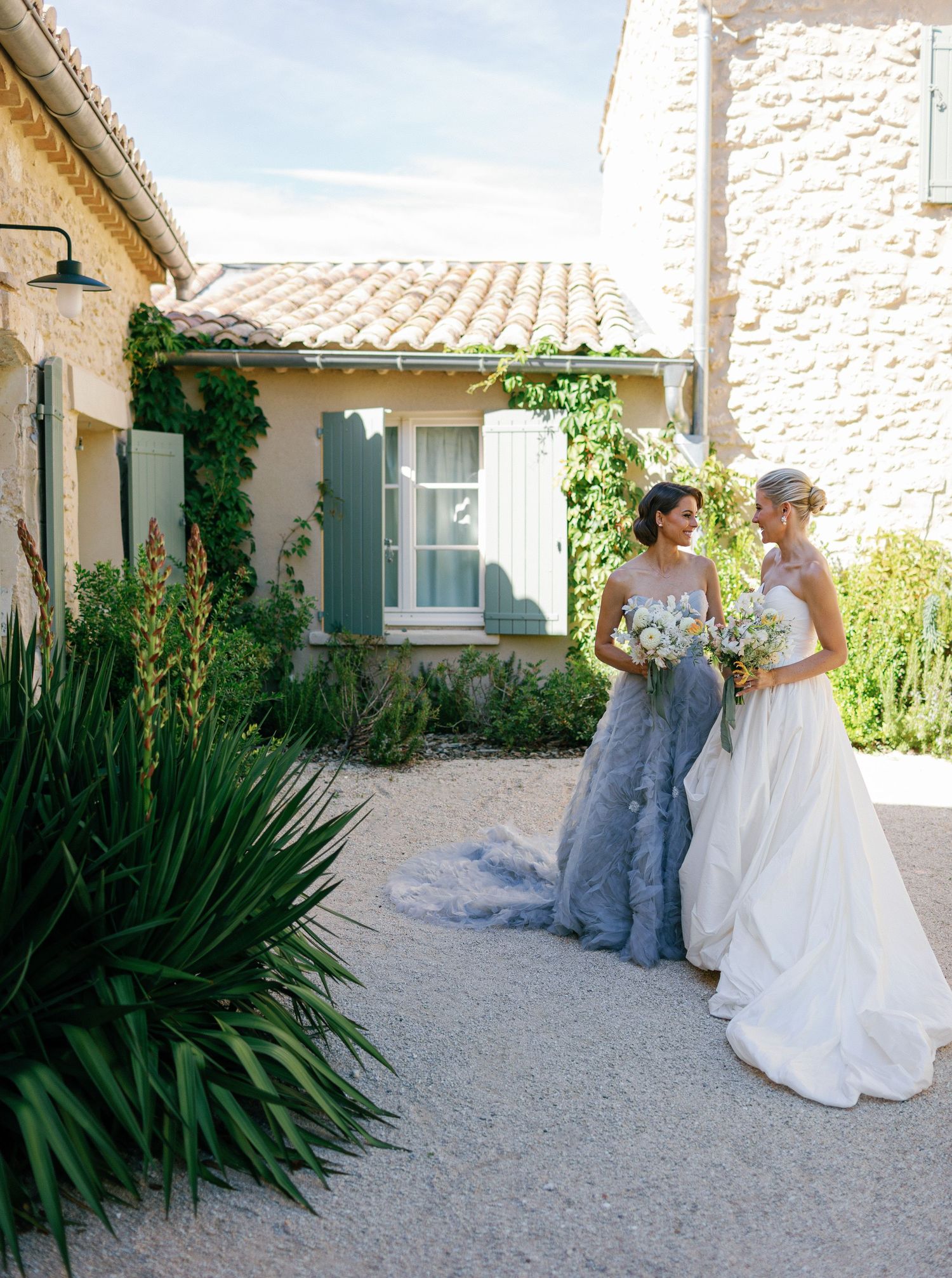 A series of outdoor wedding photos showing people in formal attire posing together on a stone pathway near a stucco building.
