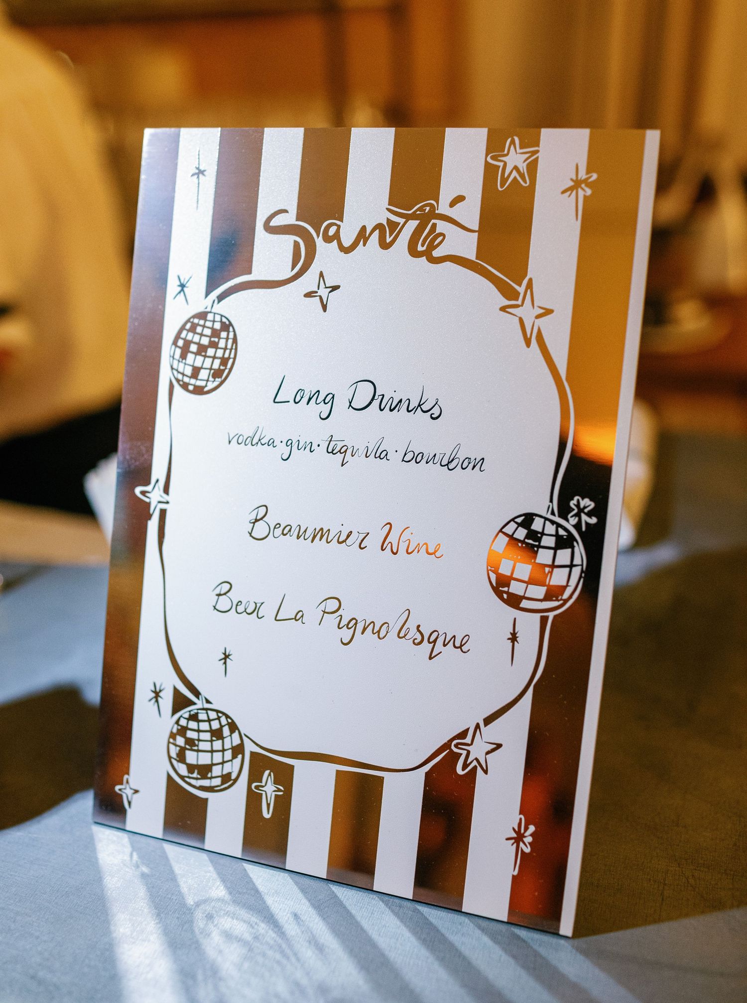 Handwritten place cards with decorative stars and stripes in brown and white color scheme for table settings.