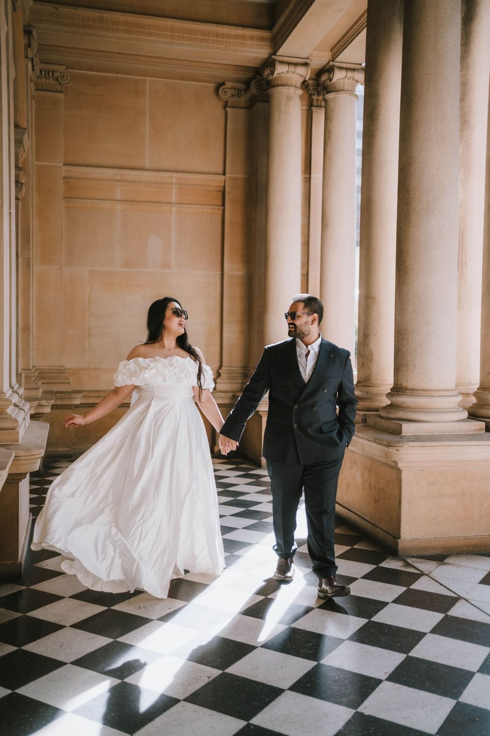 A series of elegant wedding photos showing a couple dancing in a grand hallway with checkered floors and columns.