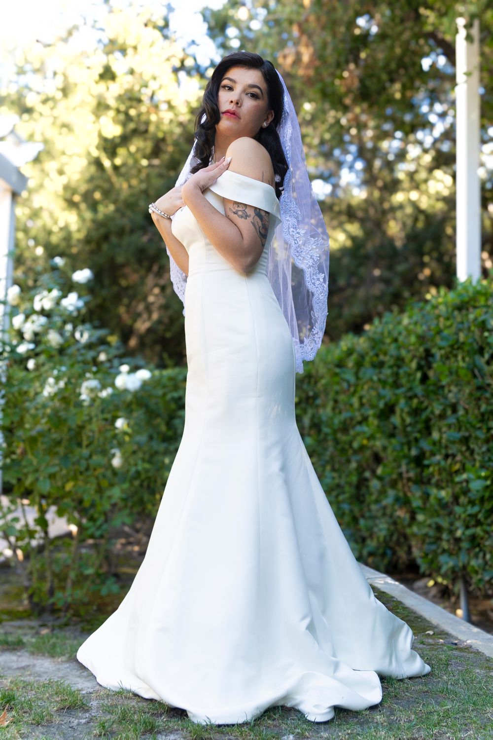 A bride posing for a photo while holding her hands to her chest