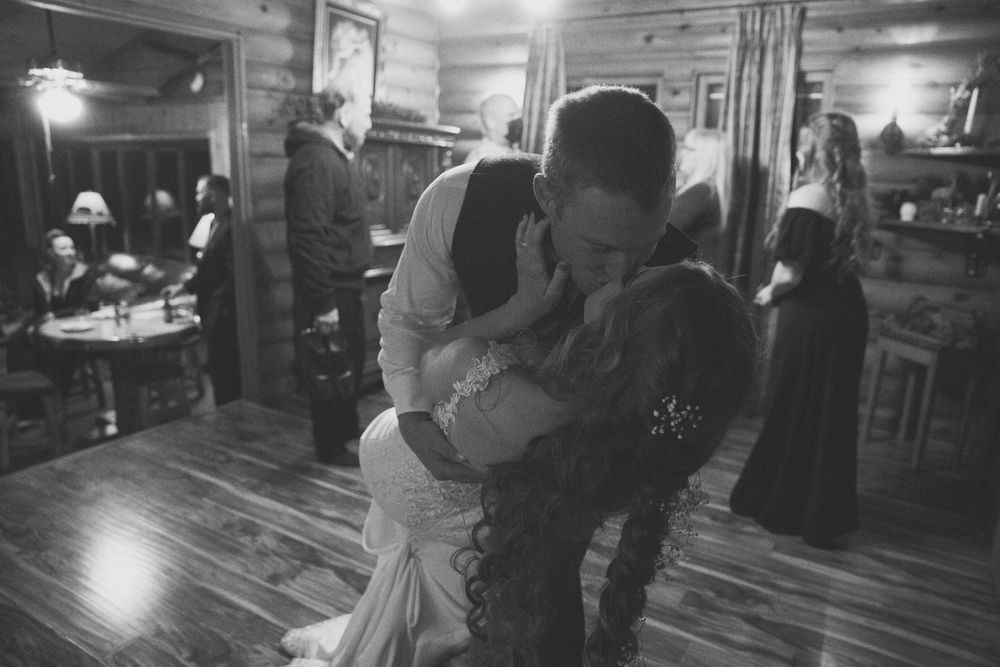 A black and white photo of a bride and groom kissing on their first dance.