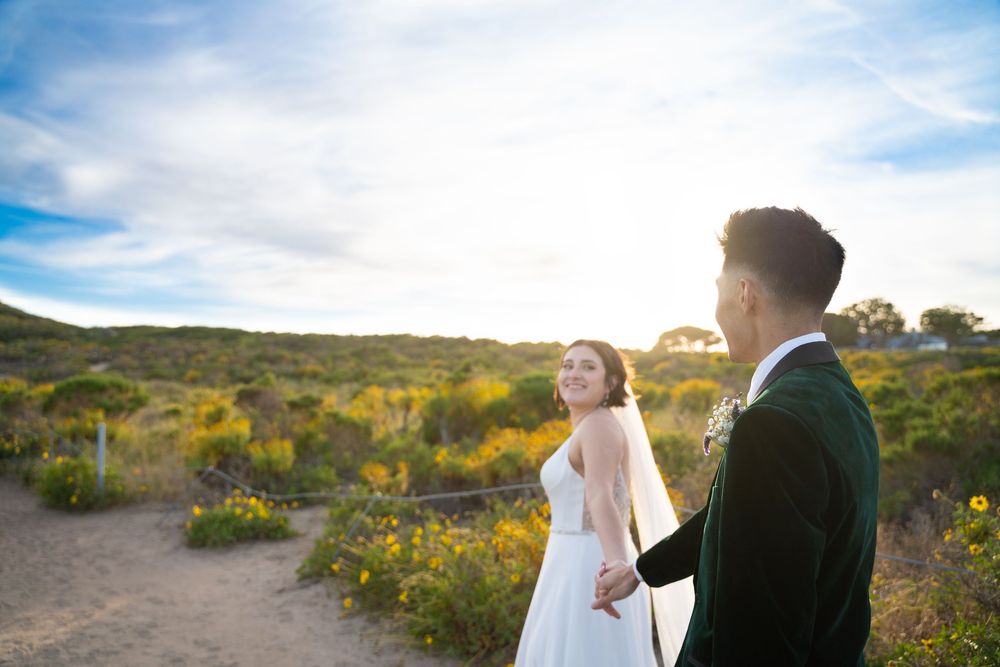 A bride and groom holding hands out by Malibu beach on their elopement.