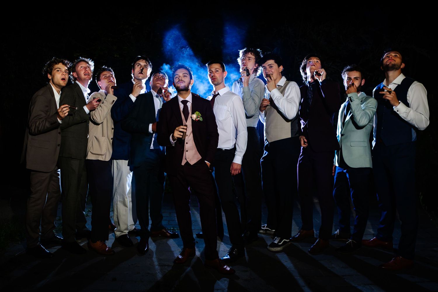 Mannen roken sigaar van vrijgezellenfeest 's avonds buiten tijdens het feest