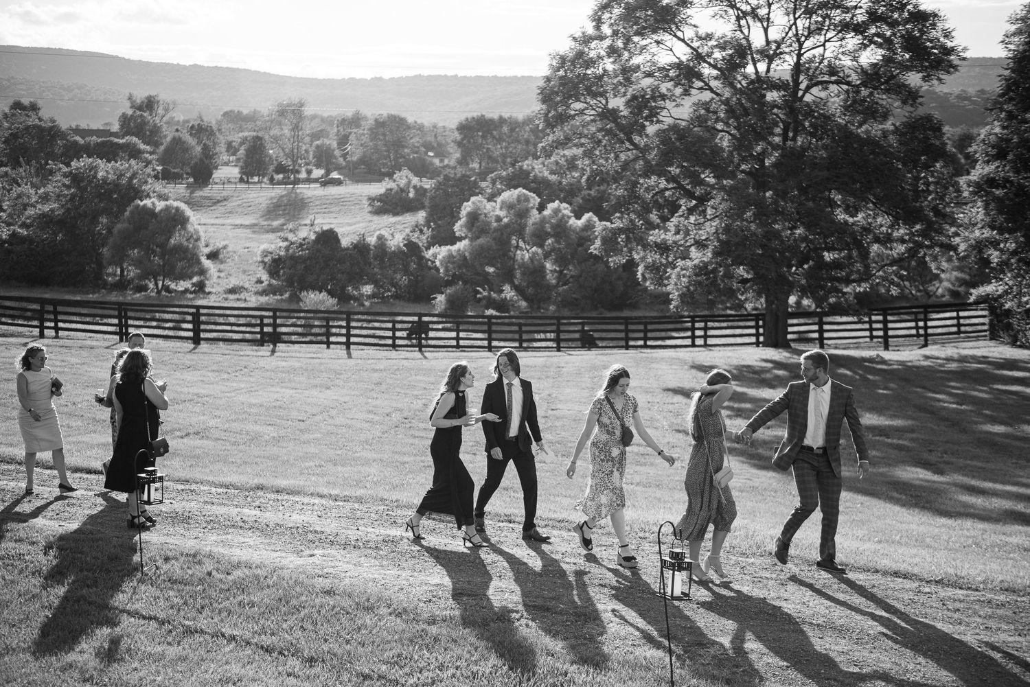 Intimate moment captured with mountain landscape and pasture fencing in background.