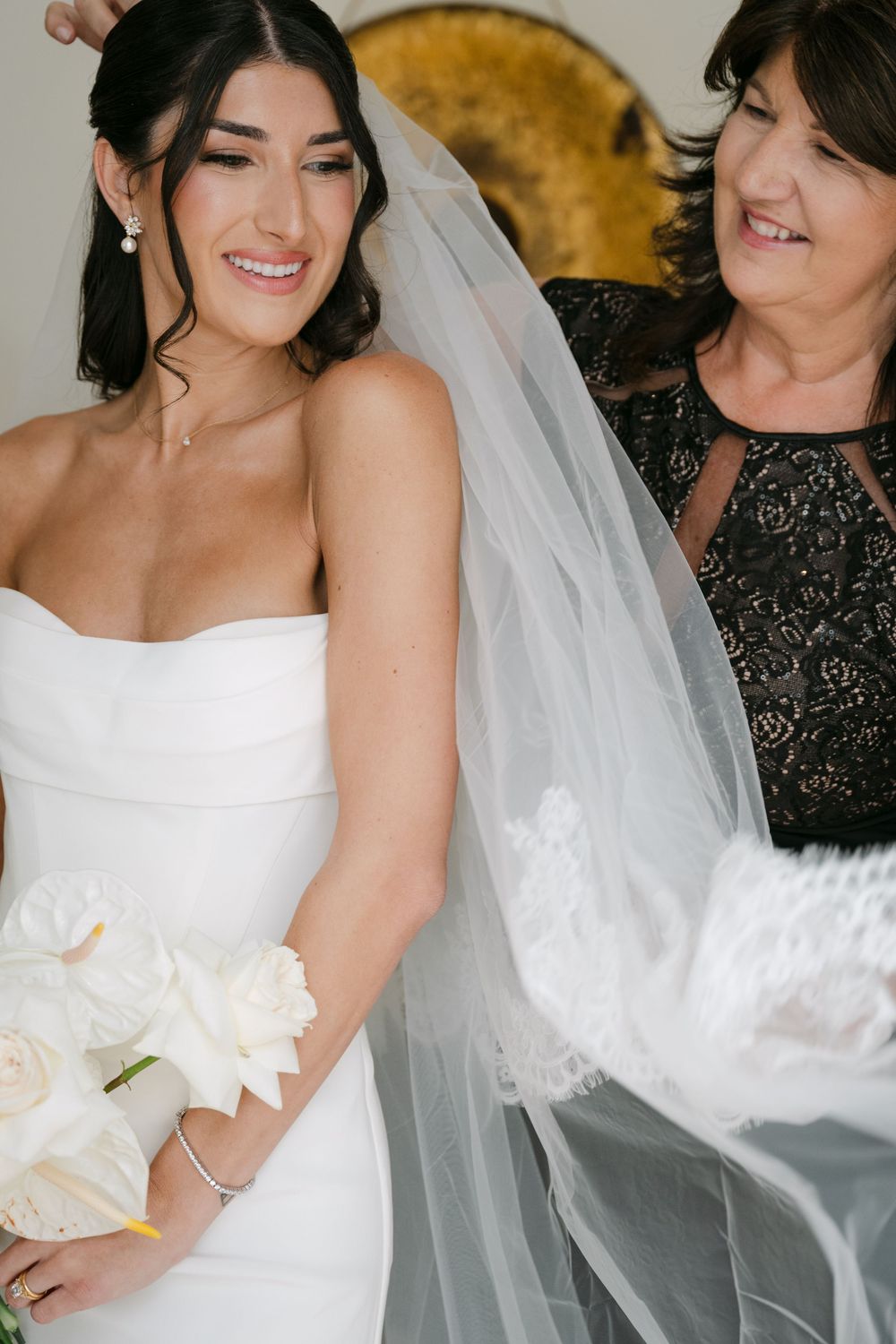 A tender bridal moment showing a traditional white wedding dress and flowing veil.