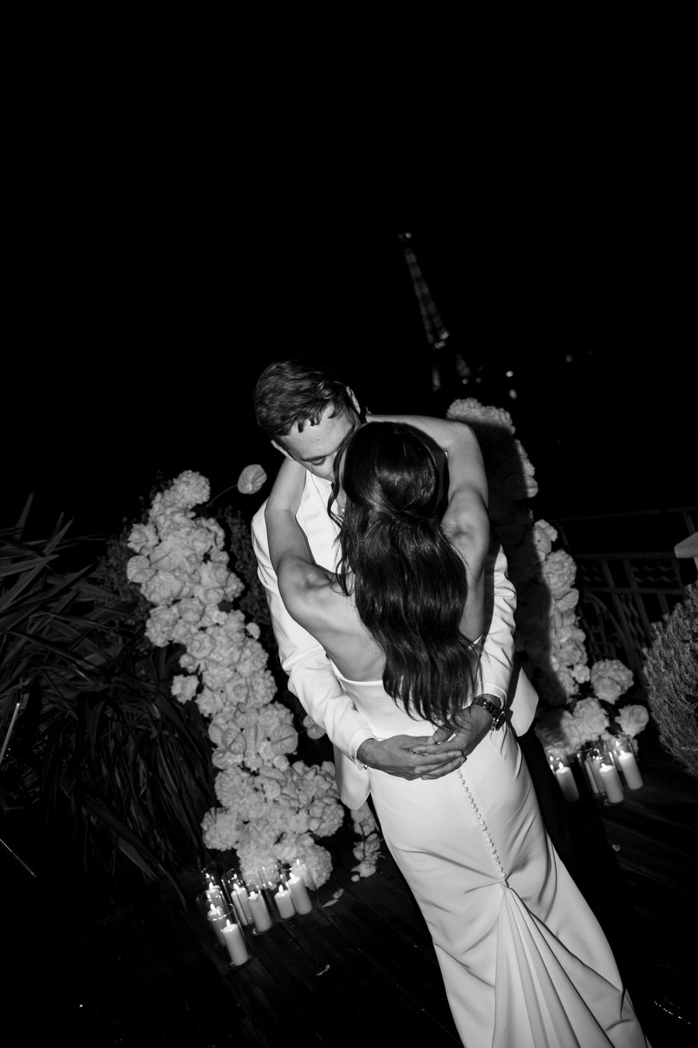 A romantic dance between newlyweds captured in black and white at night.