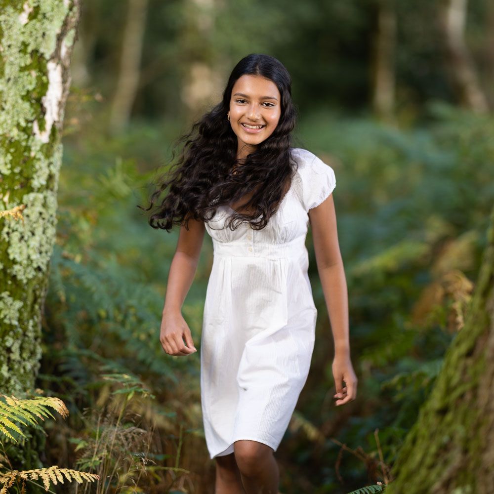 Stylish portrait of young girl in white dress in Kent woods