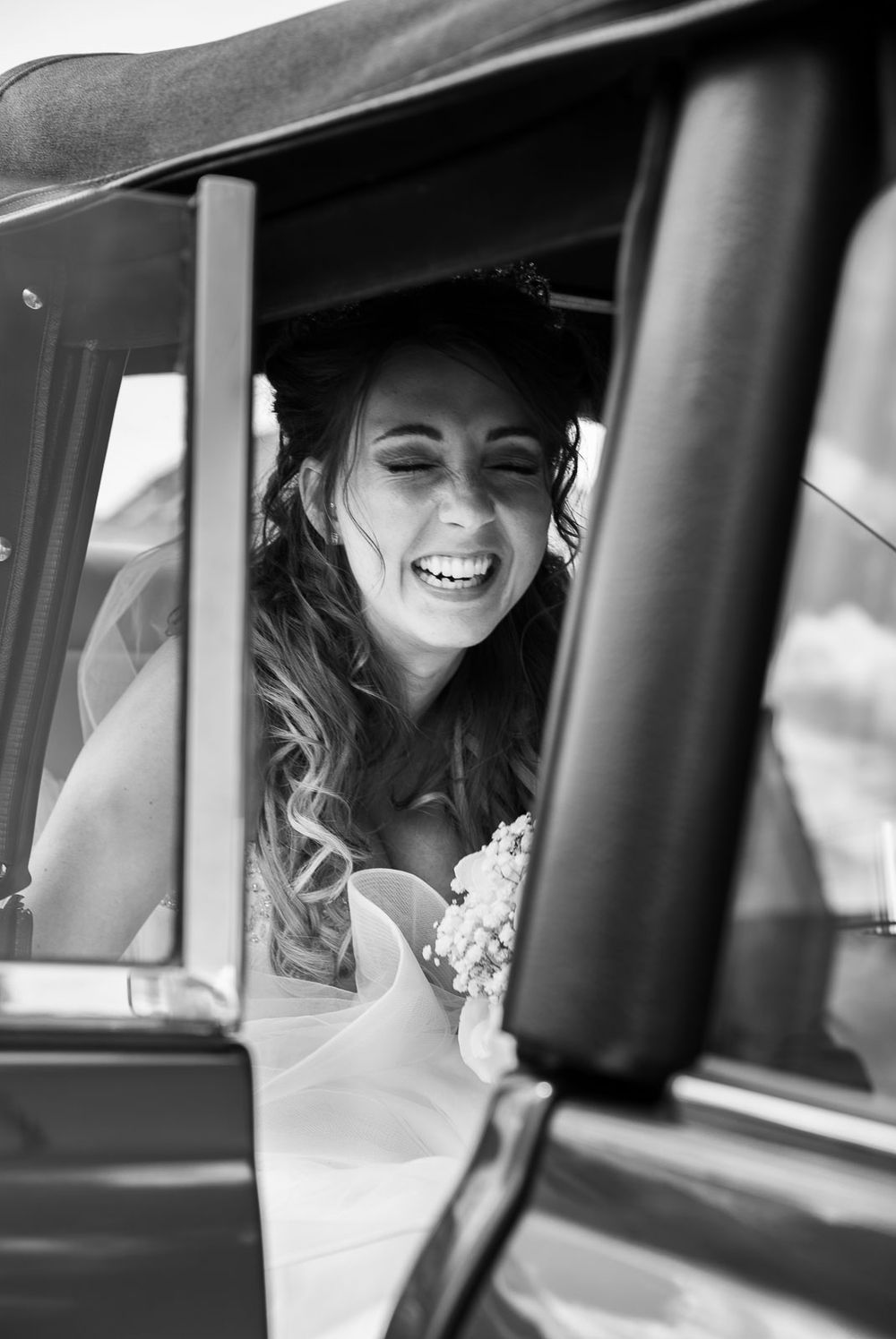 Bride laughing in car
