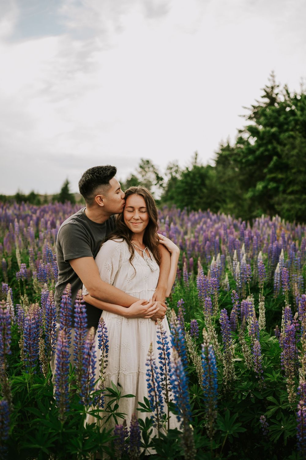 Couple holding each other in lupine field Comox Valley wildflower field locations Photography by Photographer Soulfull Photographs