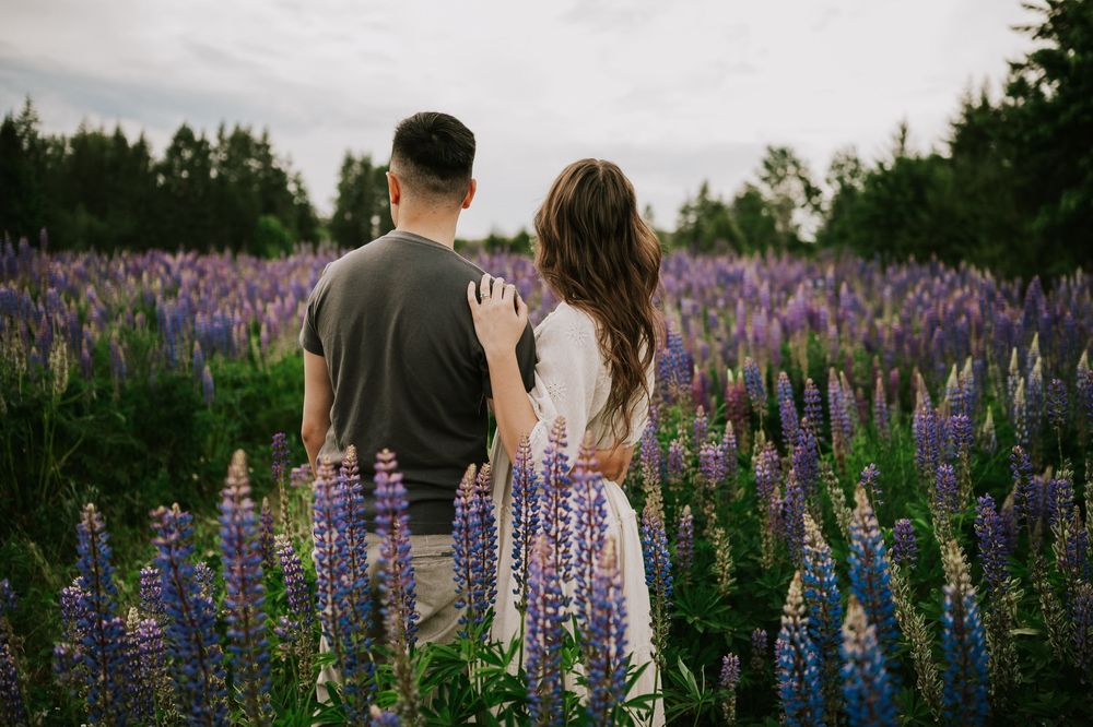 Portrait of couple looking out at lupine field Comox Valley wildflower field locations Photography by Photographer Soulfull Photographs