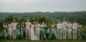 Wedding party members line up outdoors against a scenic mountain backdrop.