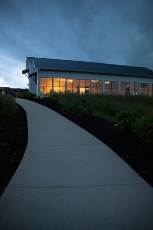 Contemporary glass building on hillside photographed during blue hour.
