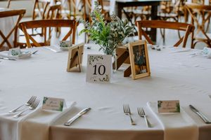 Rustic wedding table settings with wooden decor and table numbers.
