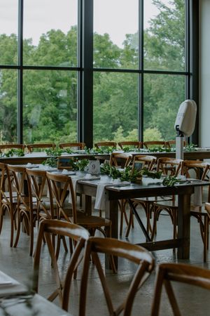 Elegant reception venue with floor-to-ceiling windows overlooking lush greenery.