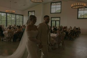 Wedding reception venue with circular chandeliers and guests seated at tables.