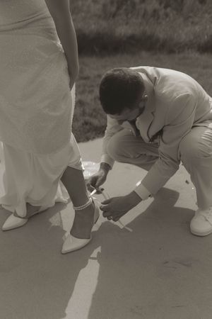 Black and white photo showing feet in white shoes lined up in a row.