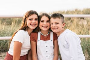 three beautiful children posing during golden hour on lake michigan shoreline