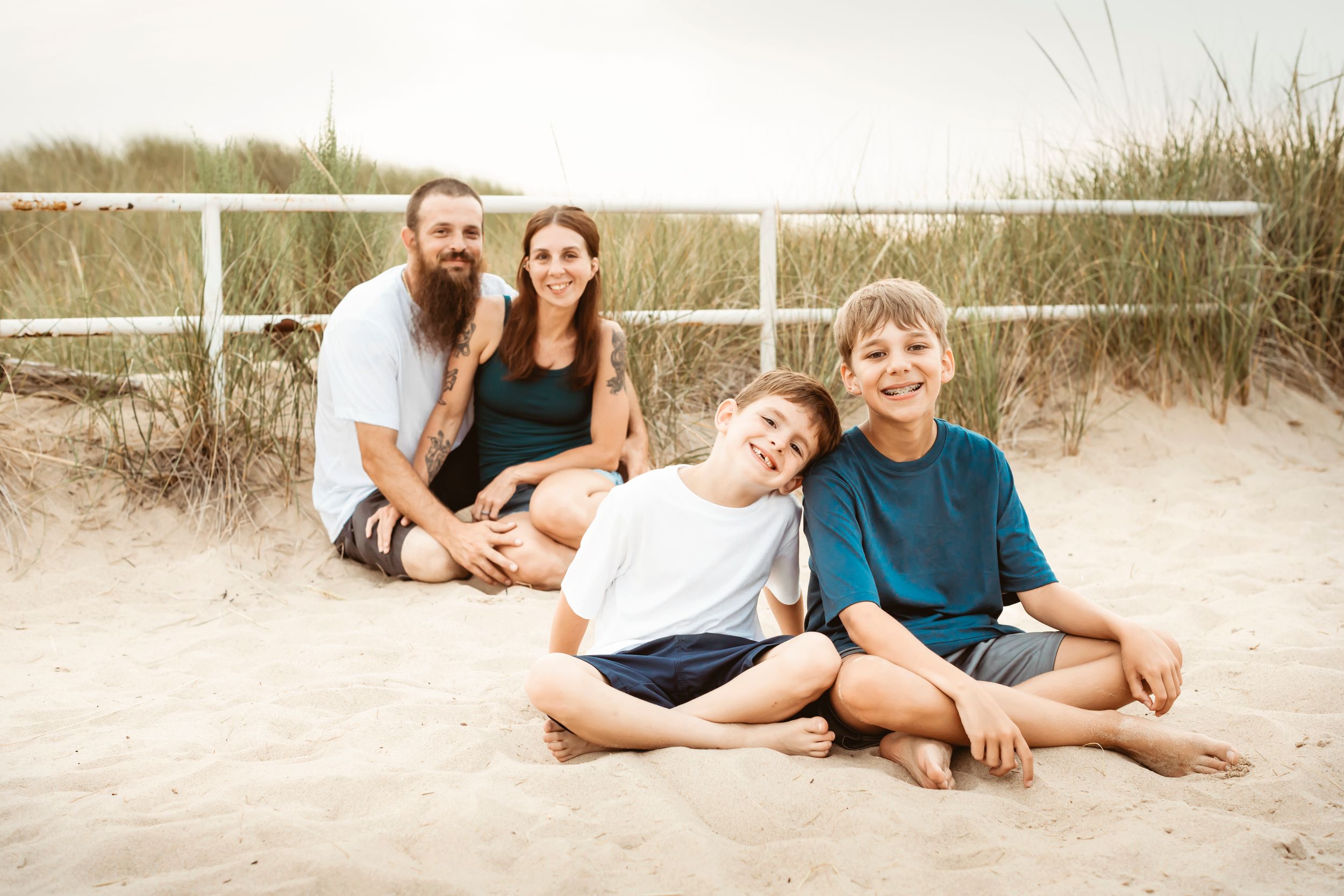 family of 4 sitting in the sand at jean klock beach benton habor mi