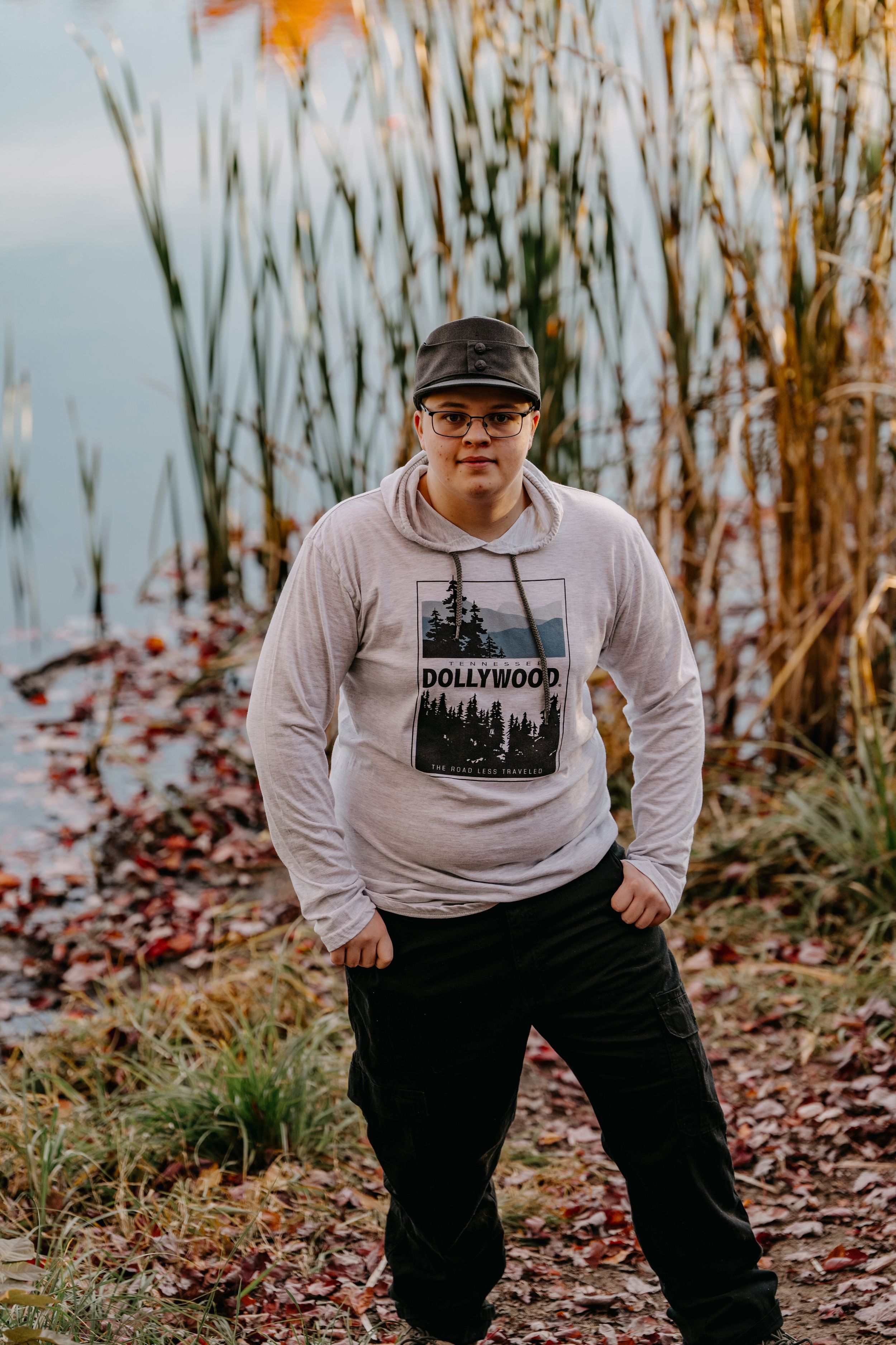 Someone poses in a Hollywood graphic sweatshirt against a backdrop of fall reeds.
