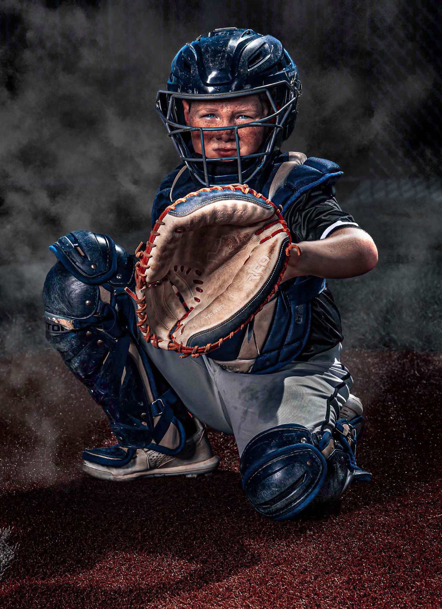A baseball player in a striped uniform practices hitting at home plate under dramatic lighting.